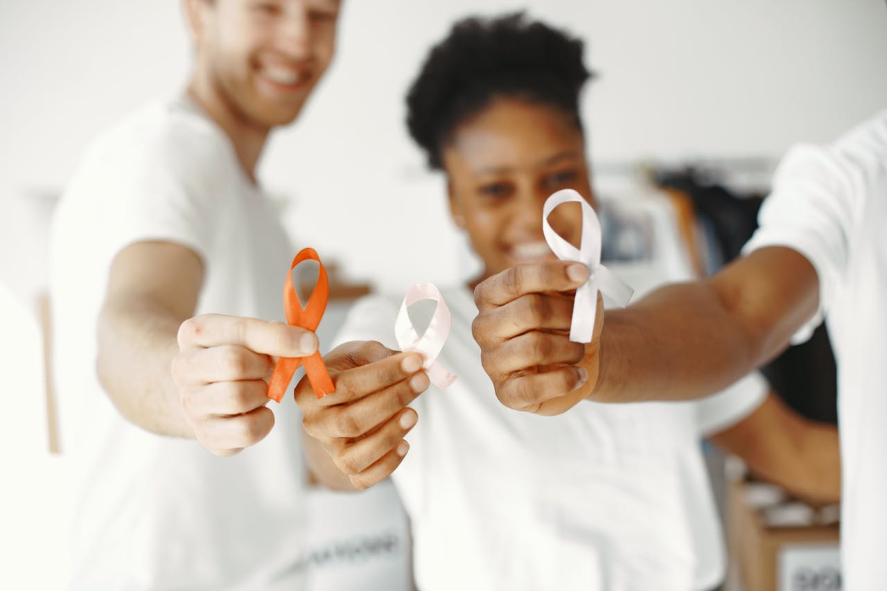 about-01 Diverse group holding health awareness ribbons, showing unity and support.